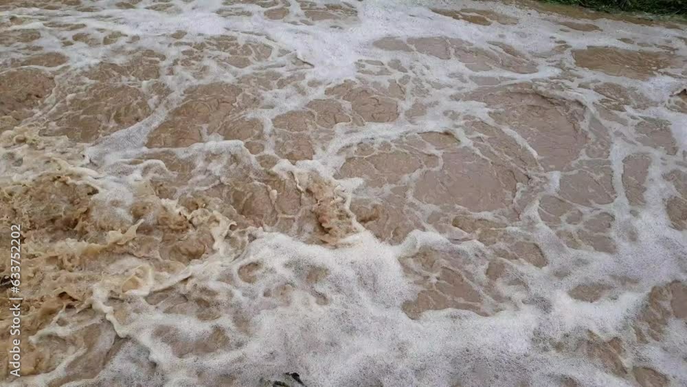 Muddy dirty water mixed with sewage flowing after heavy rains and floods in the city Muddy dirty water mixed with sewage flowing after heavy rains and floods in the city
