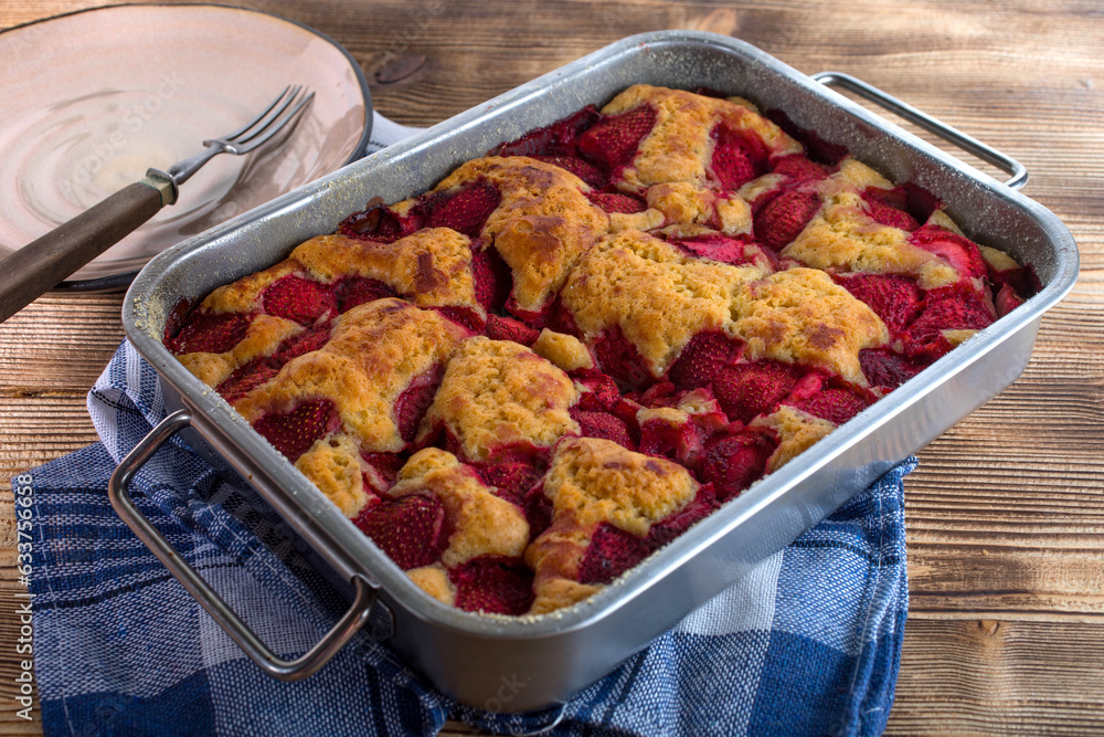 Yeast cake with strawberry in a mold.