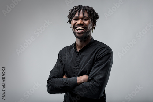 Black man, braided hair, serious, smiling, black shirt