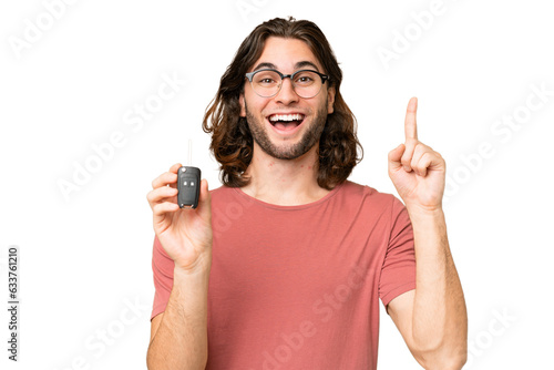 Young handsome man holding car keys over isolated background pointing up a great idea