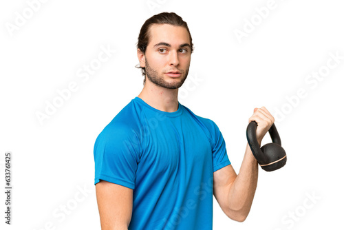 Young handsome man isolated on green chroma background making weightlifting with kettlebell