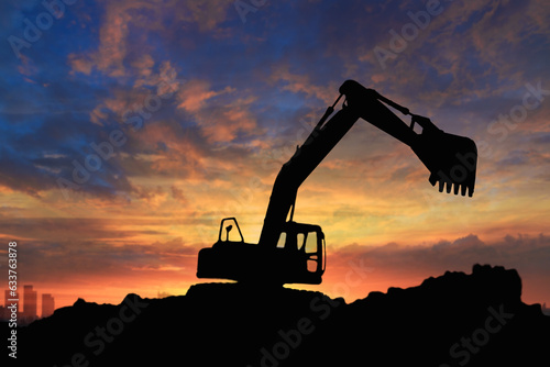 Crawler excavators silhouette are digging the soil in the construction site on the sunset background
