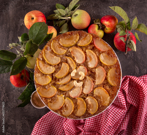 French sweet pie tart tatin apple cake upside down and fresh apples  over on old rustic wooden background. © twomeerkats