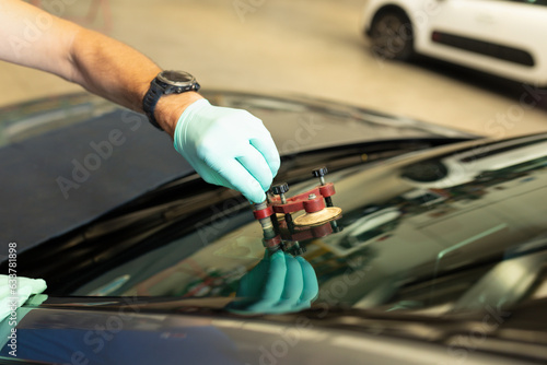 Obraz na płótnie Mechanic using repairing equipment to fix damaged windshield, windshield repairing, w salonie