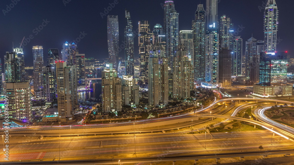Fototapeta premium Skyscrapers of Dubai Marina near intersection on Sheikh Zayed Road with highest residential buildings day to night timelapse