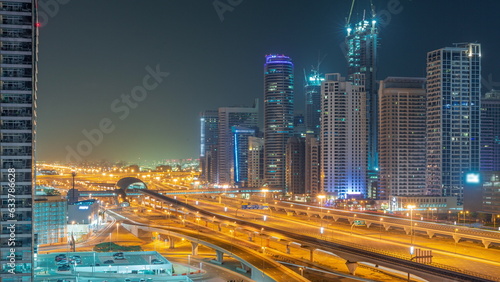 Dubai Marina skyscrapers and Sheikh Zayed road with metro railway aerial all night timelapse, United Arab Emirates