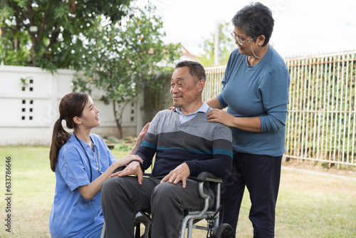 Nurse caring Asian senior man on wheelchair outdoor at hospital. Asian nurse taking care patient senior man on wheelchair
