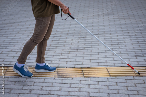 Vászonkép Close-up of the legs of an elderly blind woman with a cane at a tactile tile