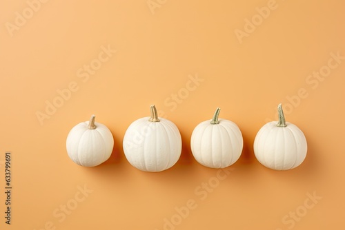 Four white pumpkins lined up in a row