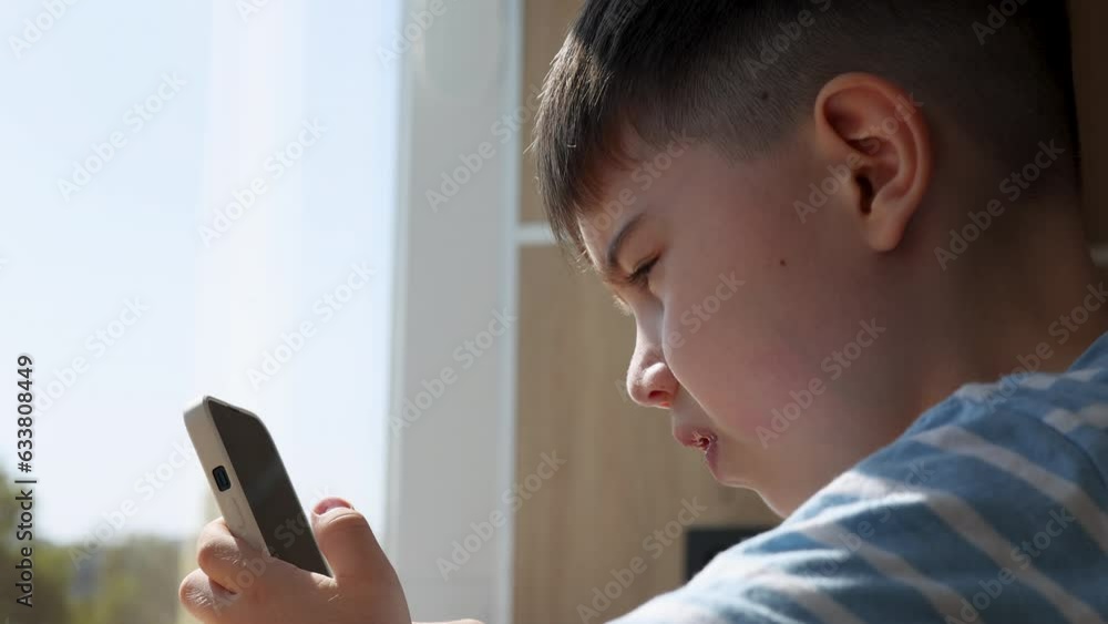 preschooler kid boy sitting at high bar table in food court with laptop or smartphone in hand.child smiling,bored or confused.large windows , sun outside. back to school, online education, remote 4k preschooler kid boy sitting at high bar table in food court with laptop or smartphone in hand.child smiling,bored or confused.large windows , sun outside. back to school, online education, remote 4k