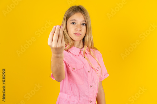 young beautiful blonde kid girl over yellow studio background Doing Italian gesture with hand and fingers confident expression