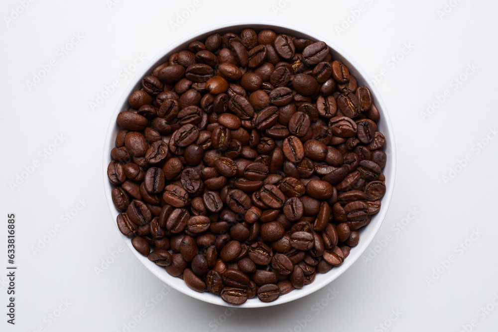 Fototapeta premium roased coffee beans in bowl on white background. Still Photo