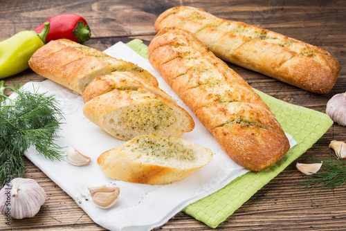 garlic baguette roll on a wooden cutting board