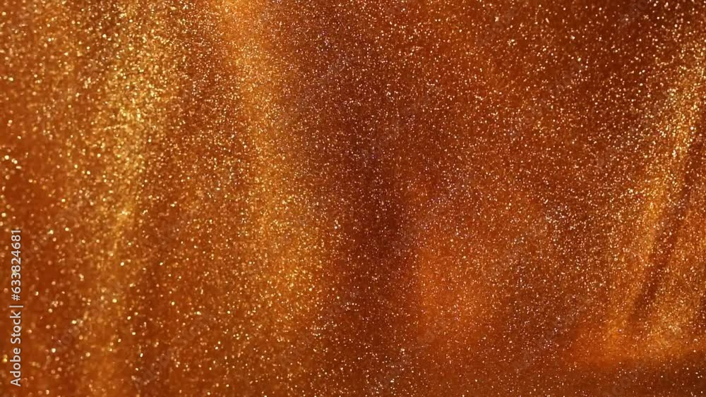 Swirls of Gold Dust Particles in Liquid. Abstract background of golden glitter particles floating in fluid. Swirls of Gold Dust Particles in Liquid. Abstract background of golden glitter particles floating in fluid.