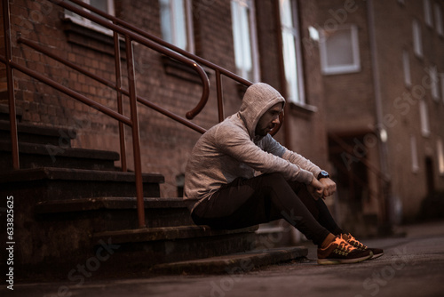 Young man resting after jogging and exercising in the city