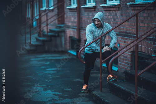 Young man stretching after jogging and exercising in the city