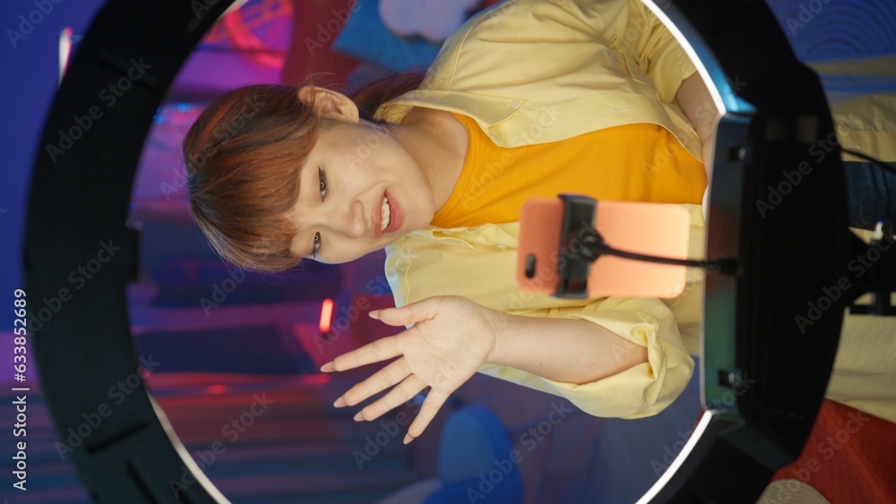 Appealing girl vlogger in casual clothing doing a live broadcast on her smartphone. Vertical photo Appealing girl vlogger in casual clothing doing a live broadcast on her smartphone. Vertical photo