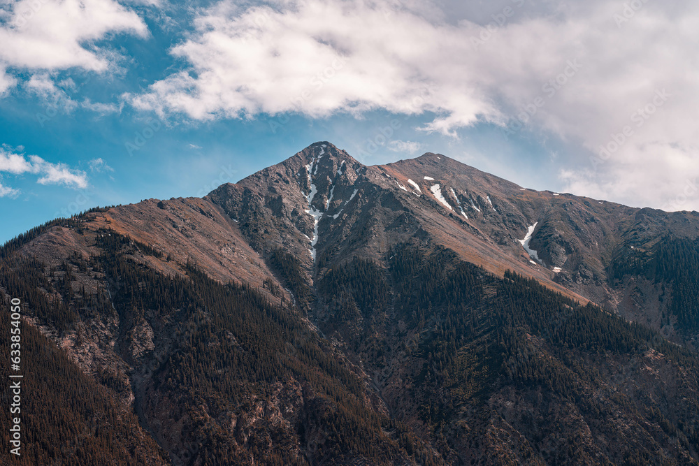 mountains with cloudy sky next to a lake mountains with cloudy sky next to a lake