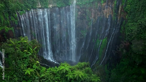 Aerial view fly through trees to Tumpak Sewu waterfall, East Java, Indonesia