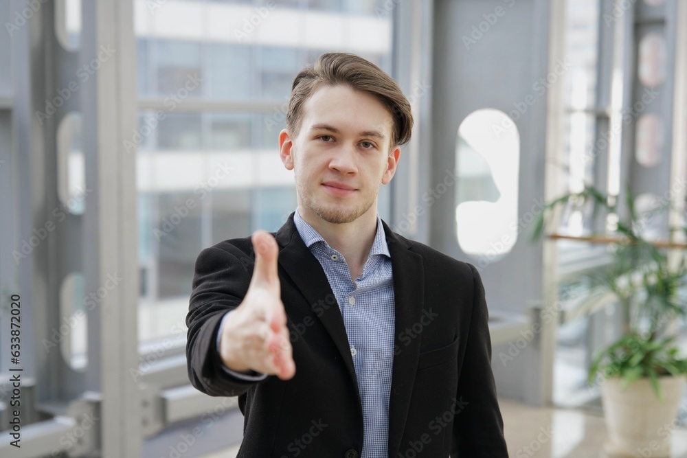 Portrait of young businessman, office worker or college or university student in shirt and jacket, suit looking at camera indoors Portrait of young businessman, office worker or college or university student in shirt and jacket, suit looking at camera indoors