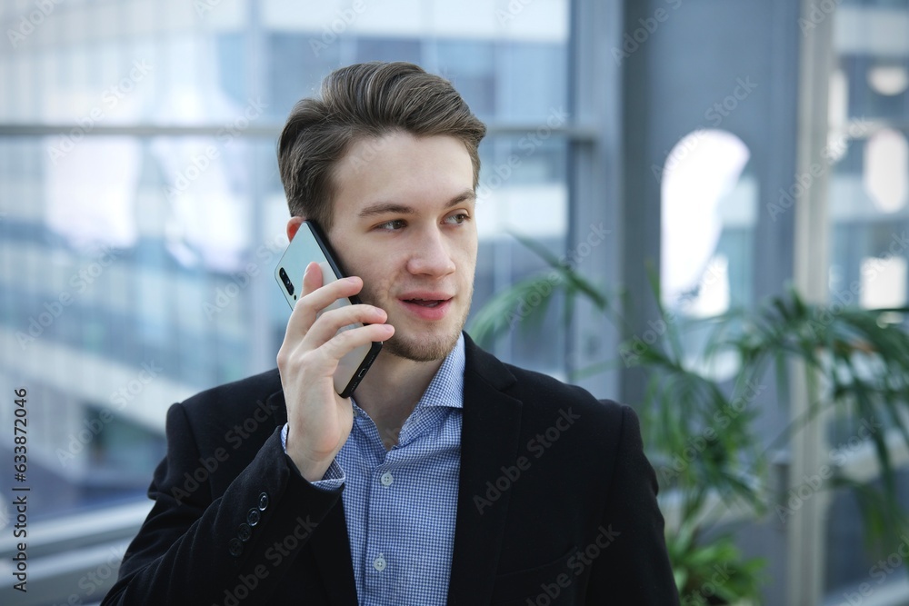 Portrait of young businessman, office worker or college or university student in shirt and jacket, suit looking at camera indoors Portrait of young businessman, office worker or college or university student in shirt and jacket, suit looking at camera indoors