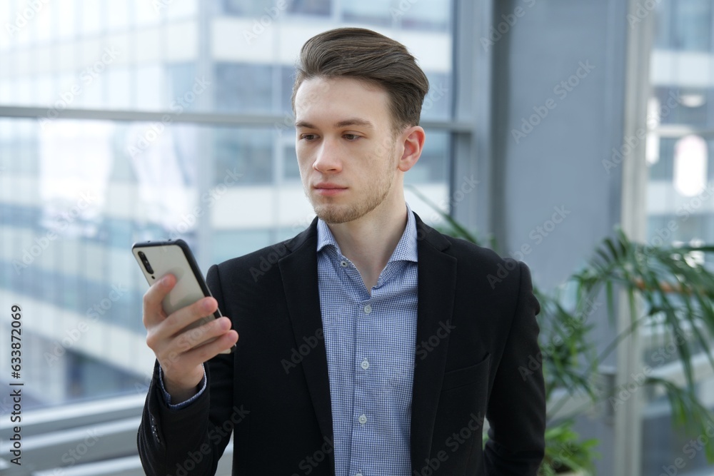 Portrait of young businessman, office worker or college or university student in shirt and jacket, suit looking at camera indoors Portrait of young businessman, office worker or college or university student in shirt and jacket, suit looking at camera indoors