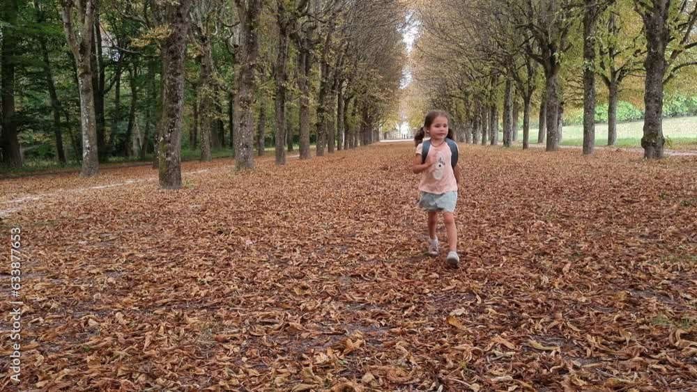 Little girl slowly running after school in autumn park on brown leaves, playing and enjoying. Relaxation, connection with the nature, childhood. High quality 4k footage Little girl slowly running after school in autumn park on brown leaves, playing and enjoying. Relaxation, connection with the nature, childhood. High quality 4k footage