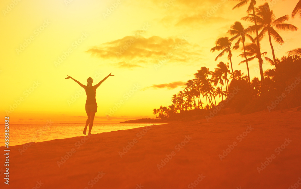 Happy joyful woman walking on the beach with arms up to the sky 