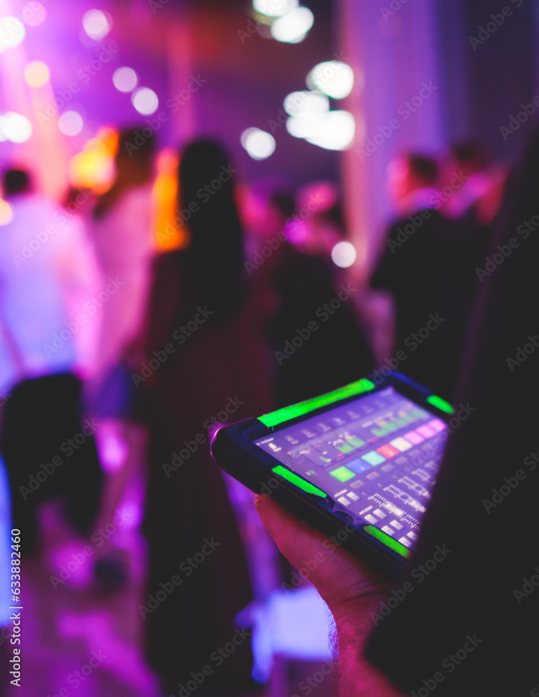 View of lighting technician with tablet, operator controlling sound and light during live event concert on stage show broadcast, technician with professional equipment, working on mixing console - obrazy, fototapety, plakaty 