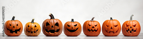 Festive lineup of Halloween jack o' lantern pumpkins on white background