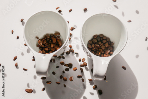 white cups and falling coffee beans.coffee levitation. Traditional morning drink.Morning refreshing drink.
