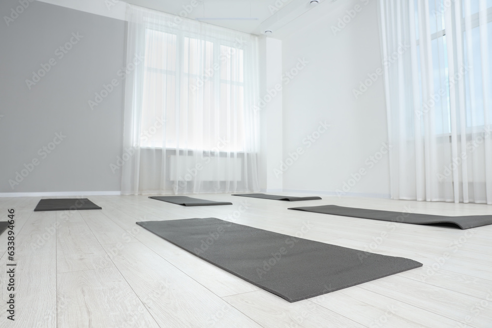 Obraz premium Spacious yoga studio with exercise mats, low angle view. Space for text