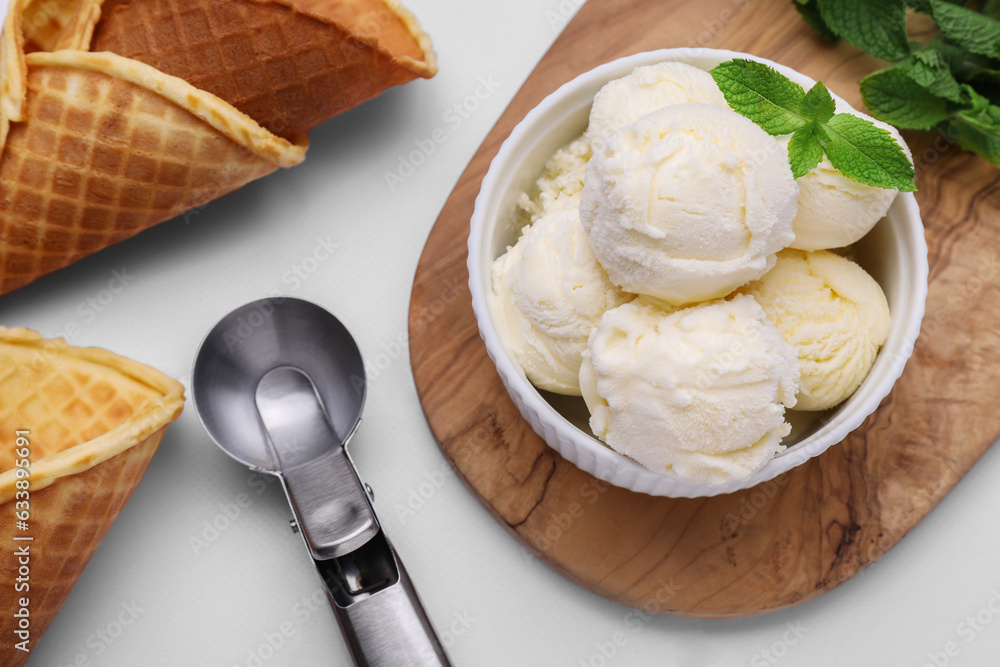 Bowl of ice cream, cones and mint leaves on white table, flat lay