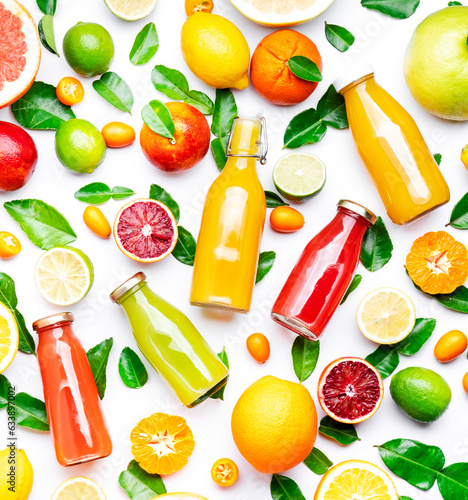 Citrus fruit juice bottles, food background. Summer drinks and beverages. Mix of different whole and cut fruits: orange, grapefruit, lime, lemon, tangerine with leaves. Top view