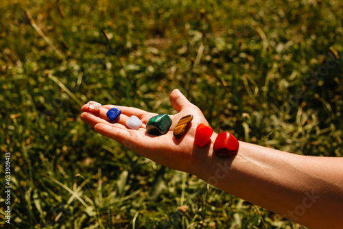 Photography Seven natural stones on a woman's hand, side view