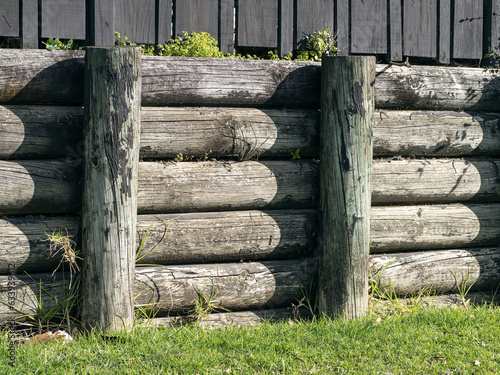 Cantilever wooden half rounds pole retaining wall. For residential sites. photo