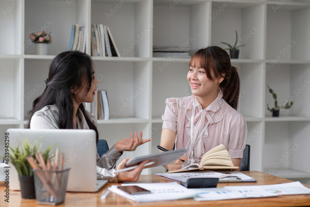 Two Young Asian businesswoman discuss with new startup project Idea presentation, analyze statistics and investment market at office Two Young Asian businesswoman discuss with new startup project Idea presentation, analyze statistics and investment market at office