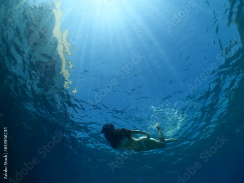 lady swims underwater with bikini sun beams and rays