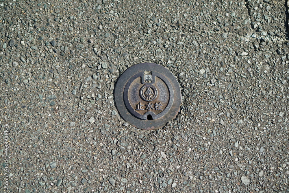 A manhole for a stopcock embedded in a city road. A manhole for a stopcock embedded in a city road.