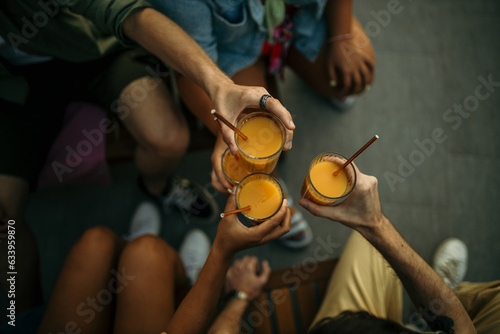 Photography Group of people holding juices and mingling around the pool, all dressed up for a fun summer enjoyment