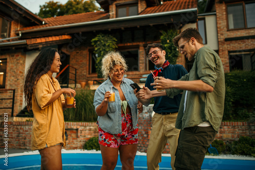 Group of well dressed crowd at a pool party dancing and having fun.