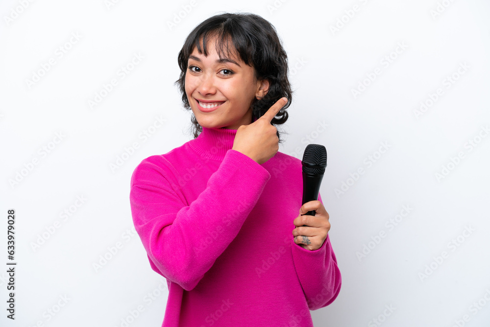 Young Argentinian singer woman isolated on white background pointing back Young Argentinian singer woman isolated on white background pointing back