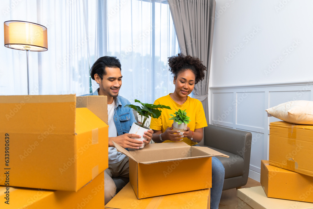 Fotografía Young couple unpacking cardboard boxes at living room