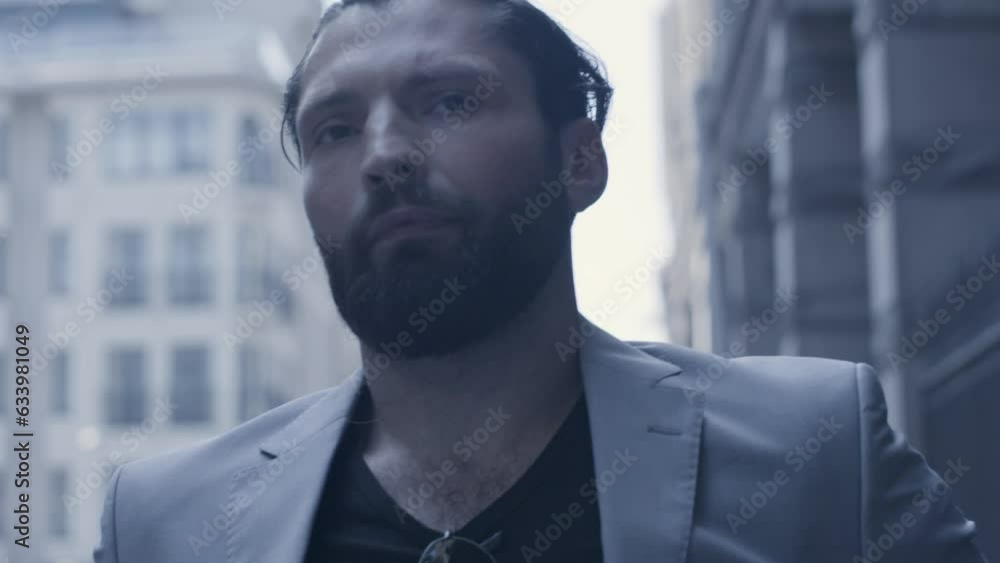 Closeup of handsome bearded man in the suit walking on the street
