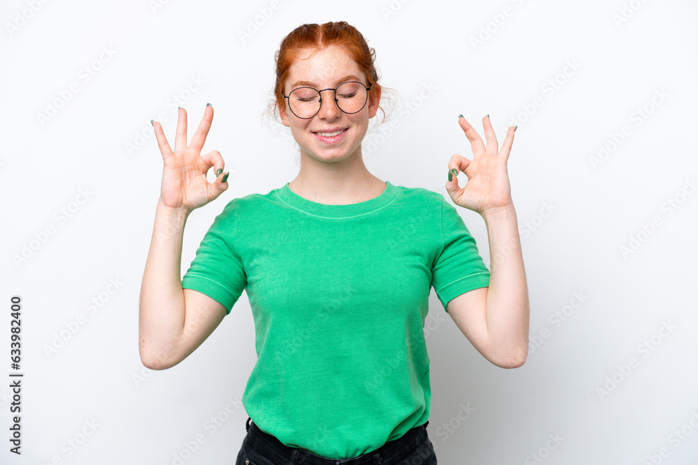 Fototapeta premium Young reddish woman isolated on white background in zen pose