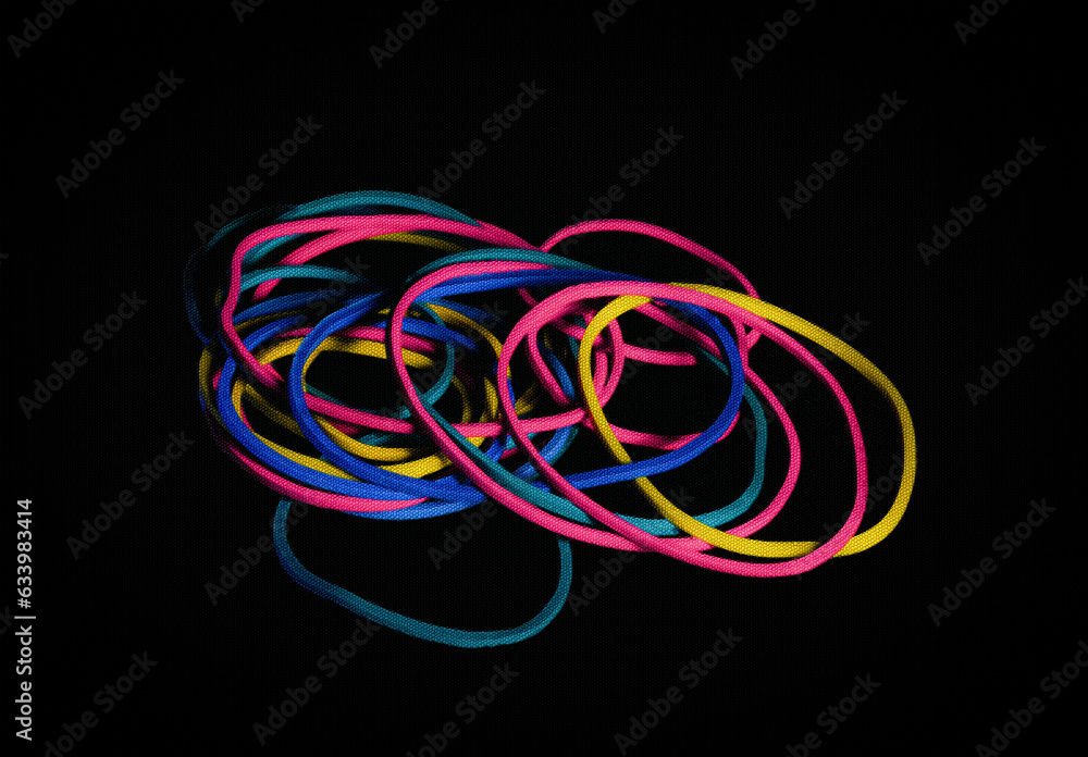 A closeup image of colorful rubber bands photographed with a black screen overlay.