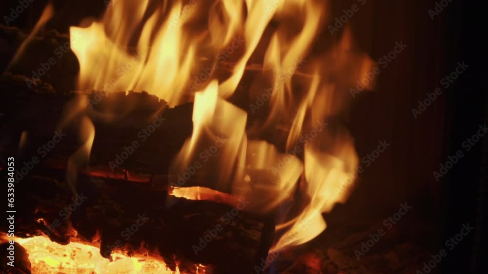 Red hot stack of firewood burns in real fireplace, close-up. Flame rises from burning birch firewood, no people. Hot yellow coals lie at the bottom of furnace. Heating the room on cold day. Red hot stack of firewood burns in real fireplace, close-up. Flame rises from burning birch firewood, no people. Hot yellow coals lie at the bottom of furnace. Heating the room on cold day.