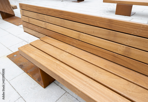 Modern public bench of a city made of teak wood and rusty iron