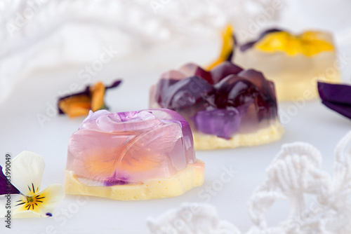 Unique japanese dessert Havaro of jelly and bavarian cream with edible violet flowers. Gelatin healthy eating dessert.