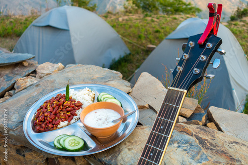 Fototapeta Naklejka Na Ścianę i Meble -  Uttarakhand camping vibes: Rajma-chawal feast with curd and salad, set against tents and guitar strums.